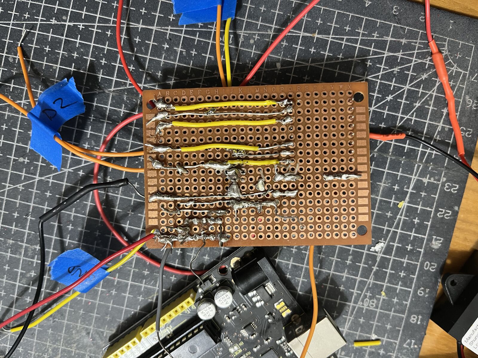 The soldered board, back side, with the solder joints and bare wire