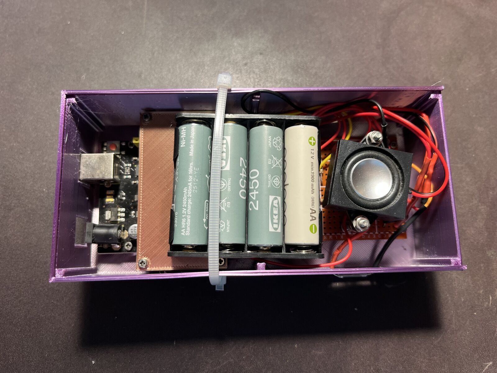 The finished chime packed in its box: four AA batteries, the board and a small speaker
