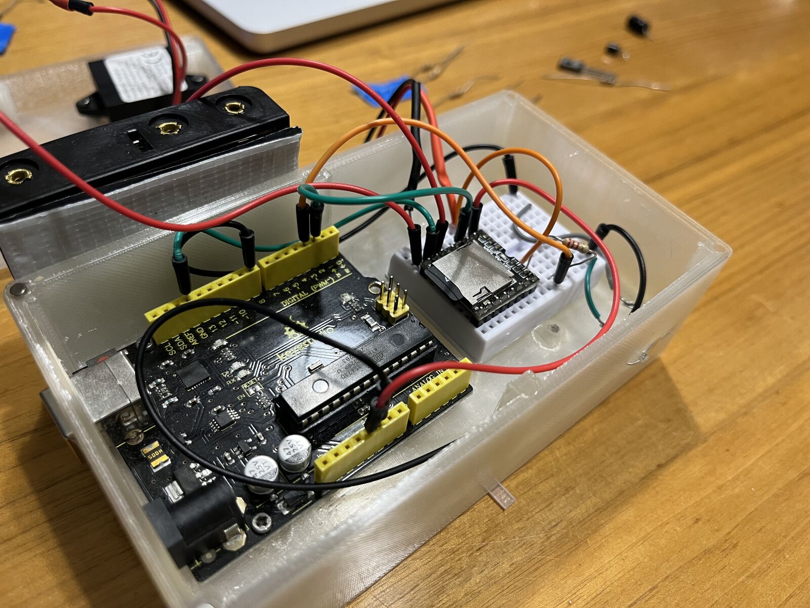 Version one: an Arduino, a breadboard and a speaker in a clear plastic box, with wires everywhere