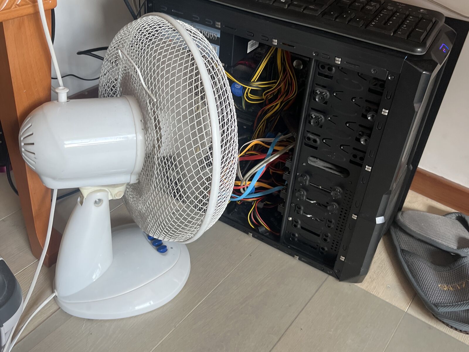 The home server with its side panel off and a white desk fan pointed at it